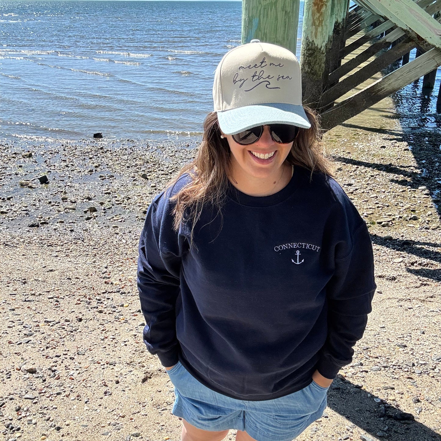 Meet me by the sea trucker cap modeled on a beach in Connecticut