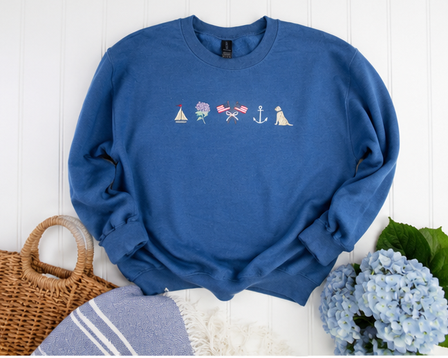 Blue Sweatshirt with embroidered designs on a white background.